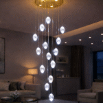 Elegant cascading chandelier lighting in a modern double height living room with gold ceiling plate and crystal pendant drops.