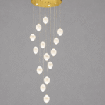 Elegant cascading chandelier lighting in a modern double height living room with gold ceiling plate and crystal pendant drops.